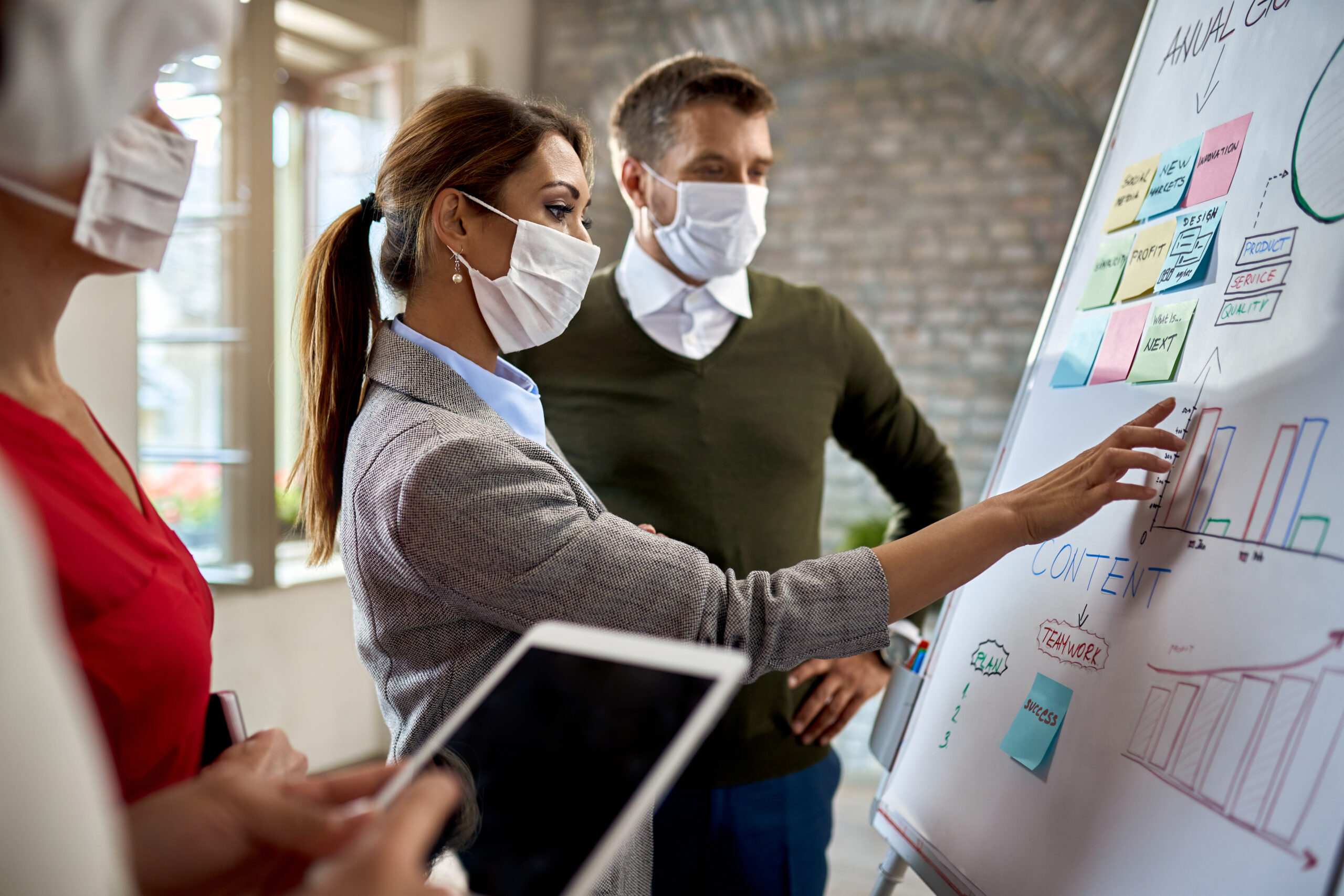 Businesswoman,And,Her,Coworkers,Wearing,Protective,Face,Masks,While,Making